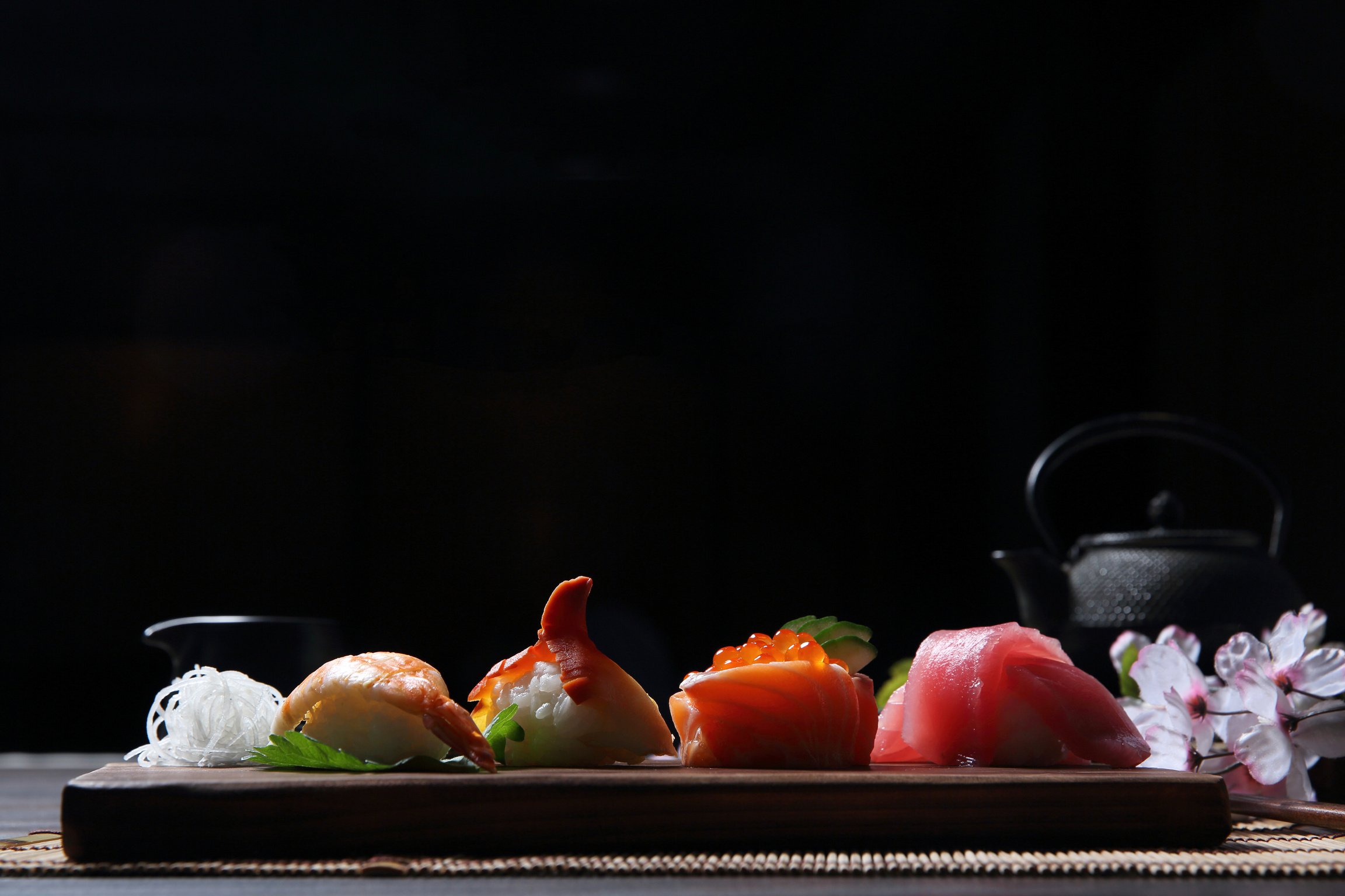 Sushi Set sashimi and sushi rolls with tea on wood background